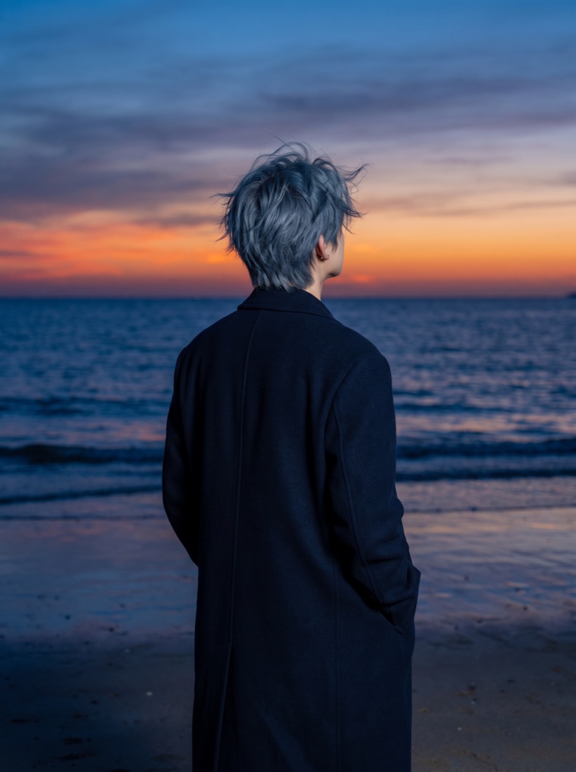 夕暮れの海を見つめるisanaの後ろ姿
